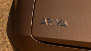 Rear Ariya model badging on the trunk of a bronze 2023 Nissan Airya all-electric (EV) compact SUV model