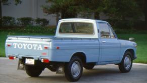 The tailgate and bed of a blue Toyota hi-lux pickup truck, trees visible in the background.