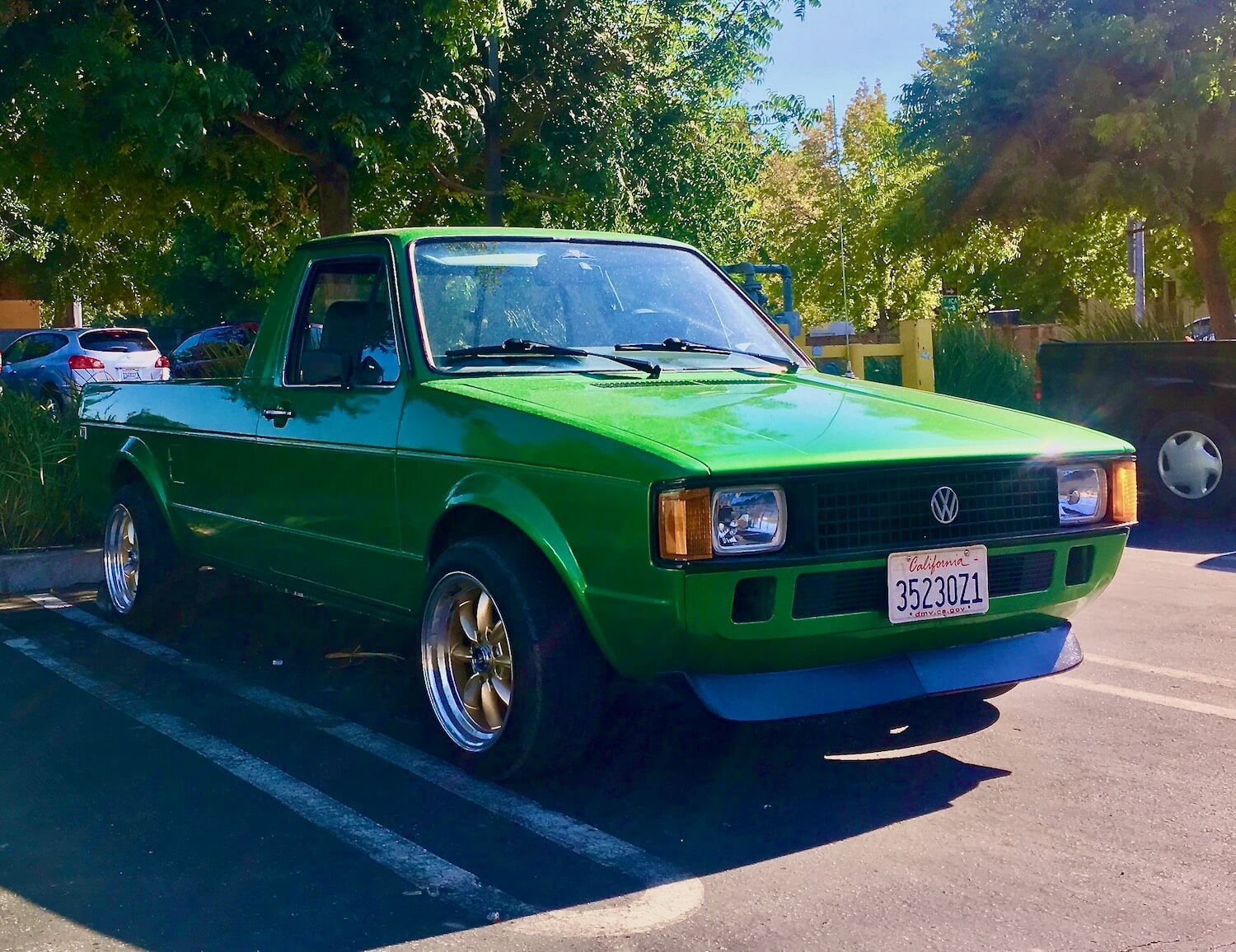 A bright green Volkswagen Rabbit pickup truck in a parking lot. 