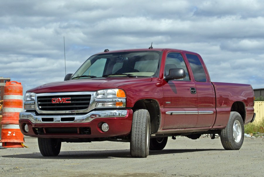 A red GMC Sierra pickup truck parked at a construction site.