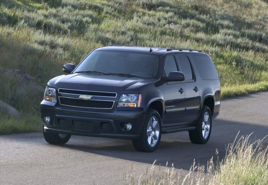 A black 2007 Chevy Suburban, which is one of the worst Chevy Suburban model years, driving outdoors.