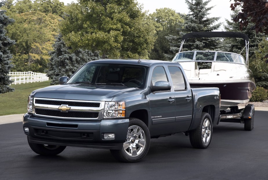 A gray Chevrolet Silverado truck towing a boat.