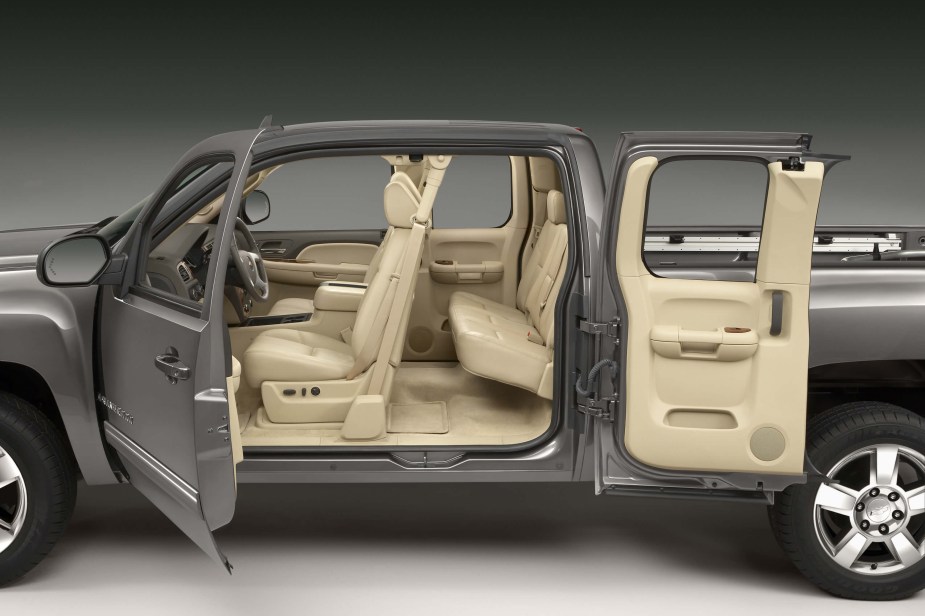 A gray Chevrolet Silverado pickup truck with a tan interior sits in a photo studio with all its doors open for a publicity photo.