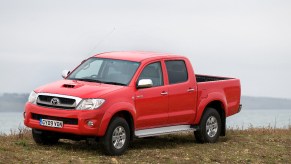 A 2009 Toyota Hilux midsize truck sits in front of some water.