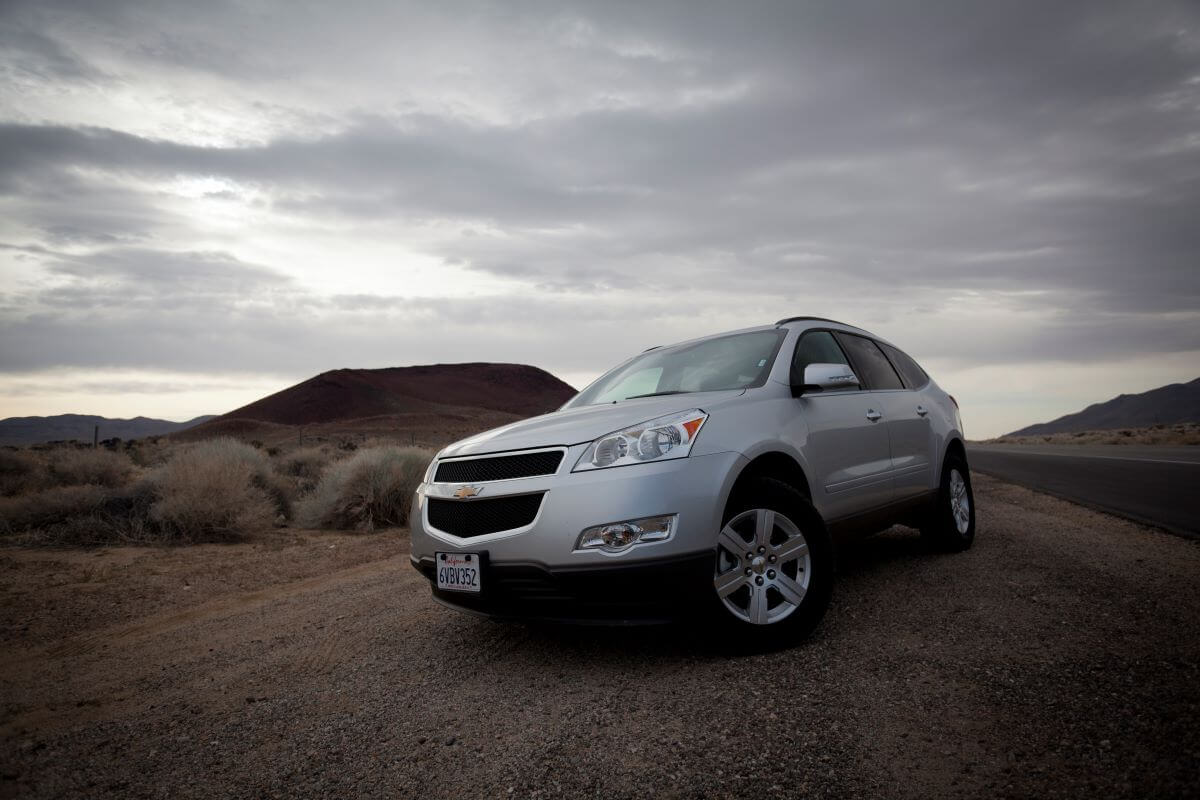 A silver 2011 Chevy Traverse full-size SUV model at State Highway 395 in the Mojave Desert