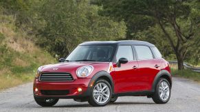 A red 2013 Mini Cooper Countryman subcompact luxury crossover SUV model parked on an asphalt road