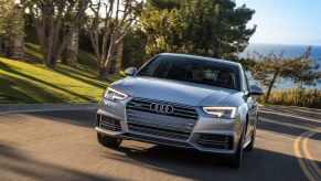 A silver 2017 Audi A4 luxury car corners on a smooth road.