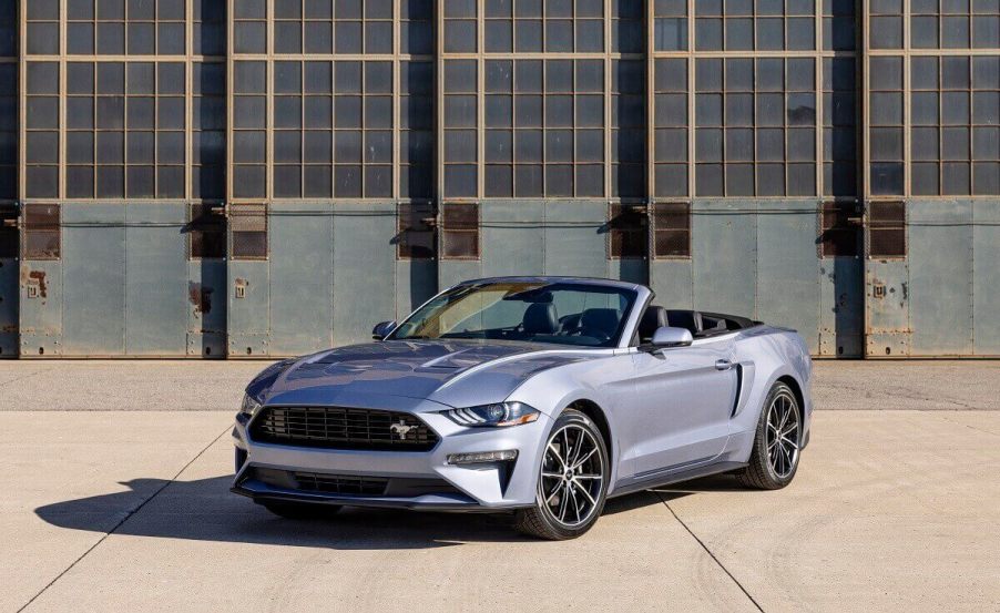 A silver 2023 Ford Mustang EcoBoost shows off its convertible car platform with the top down.