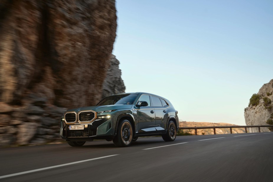 A new 2023 BMW XM drives along a desert mountain road. 