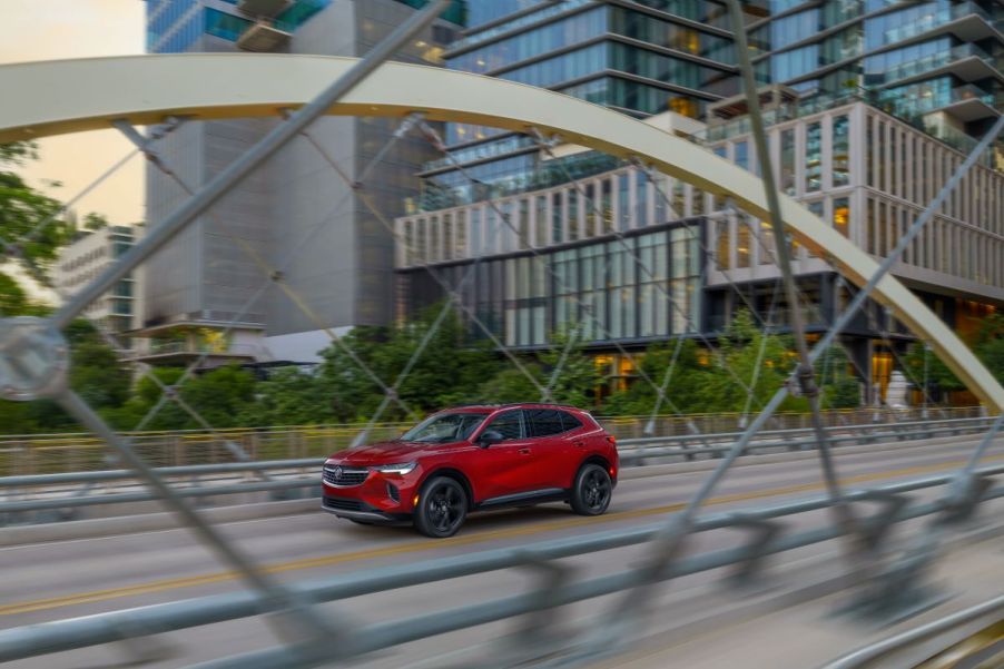 A red 2023 Buick Envision Essence drives on a bridge