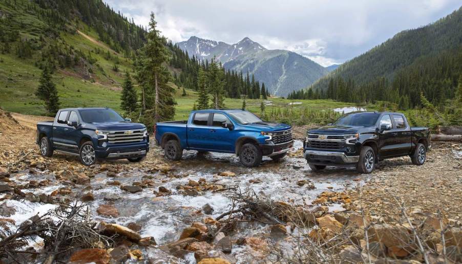 3 of the 2023 Chevrolet Silverado 1500 trucks parked outdoors in a mountainous area.