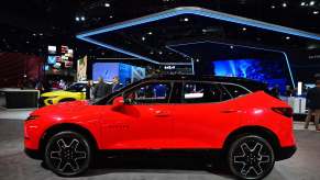 2023 Red Chevrolet Blazer at an auto show from the side.