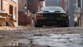 An F8-Green 2023 Dodge Challenger SRT Hellcat Widebody parks on a city street.