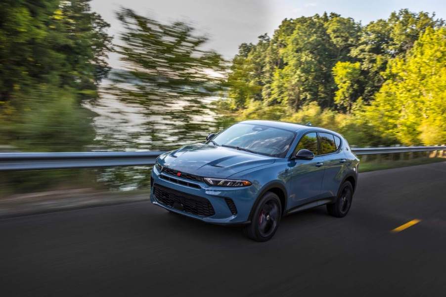 Driving the 2023 Dodge Hornet GT in gray along a forest road.