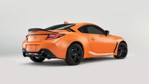 The 2023 Toyota GR86 shows off its sports car platform with bright orange paintwork.