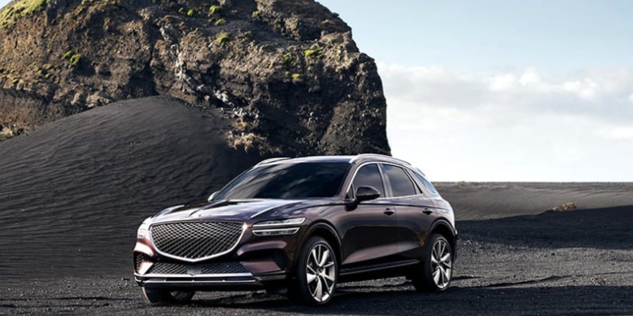 A black 2023 Genesis GV70 small luxury SUV is parked outdoors. 