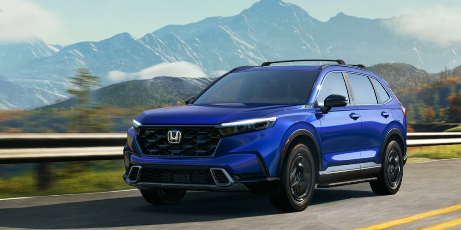 A blue 2023 Honda CR-V small SUV is driving on the road. 