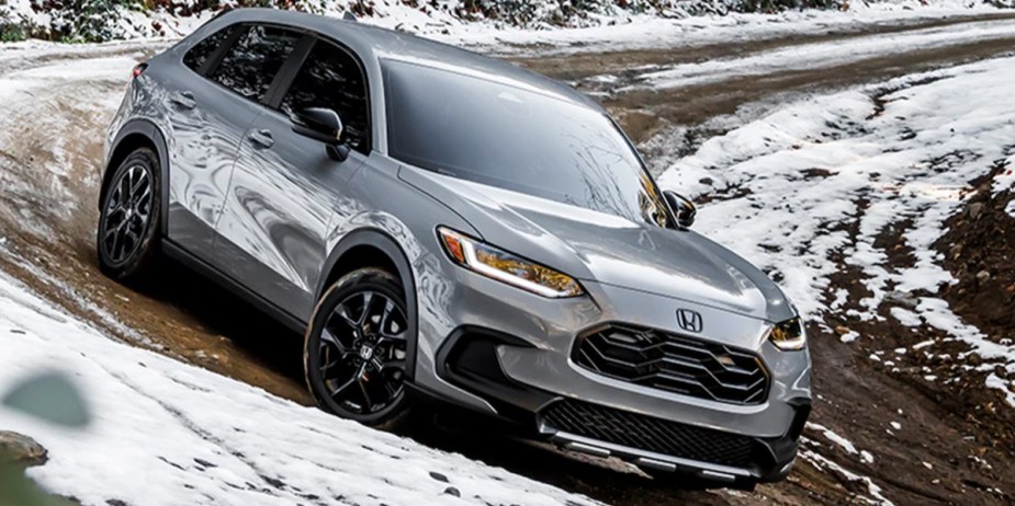 A gray 2023 Honda HR-V subcompact SUV is driving off-road. 