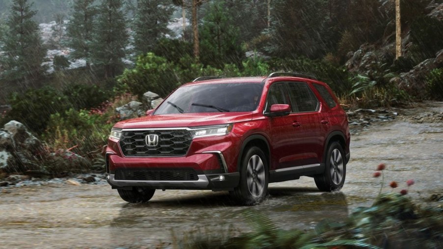 Red 2023 Honda Pilot Driving Outdoors in the Rain