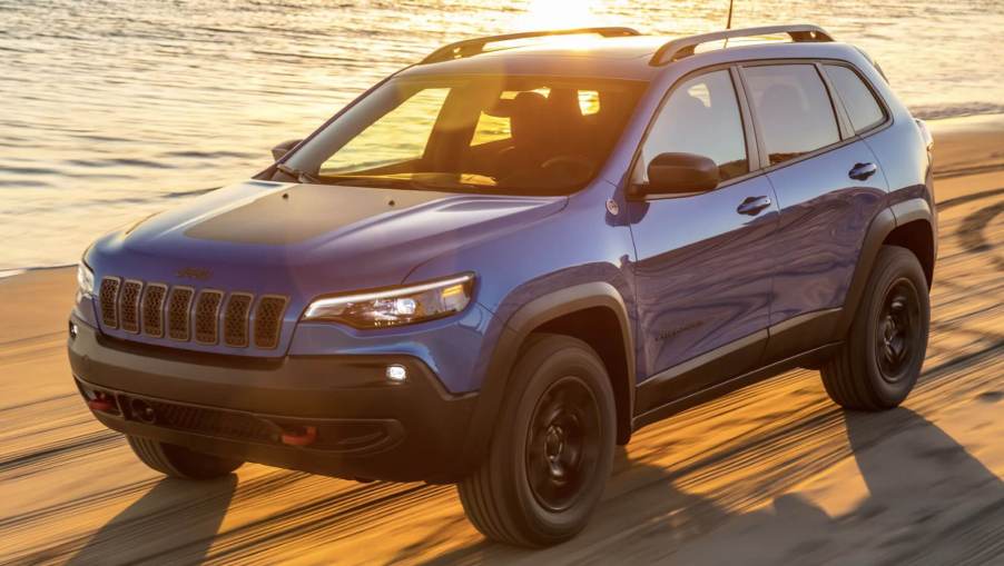 The 2023 Jeep Cherokee off-roading in sand on the beach.