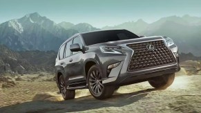 A gray 2023 Lexus GX full-size luxury SUV is driving off-road.