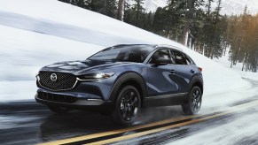 A 2023 Mazda CX-30 driving down a snowy road.