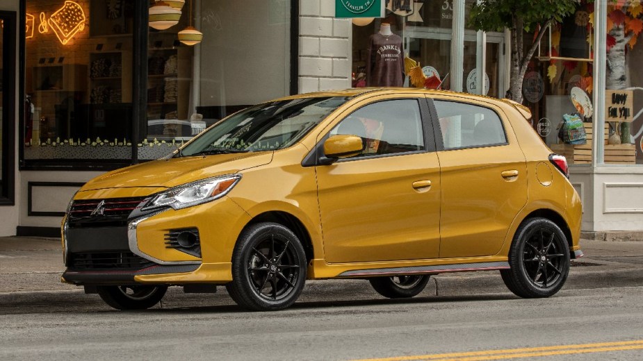 2023 Mitsubishi Mirage, gas car with best fuel economy and one of cheapest new models, parked by sidewalk 