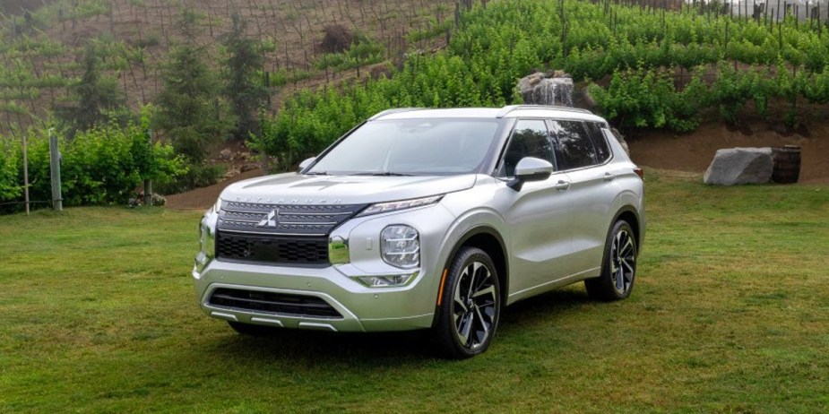 A white 2023 Mitsubishi Outlander small SUV is parked.