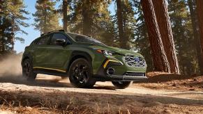 A green Subaru Crosstrek subcompact SUV is driving off-road.