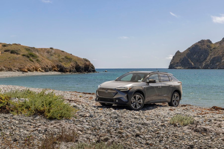 A silver 2023 Subaru Solterra parked in front of a body of water. The Solterra is the most disappointing 2023 Subaru model.