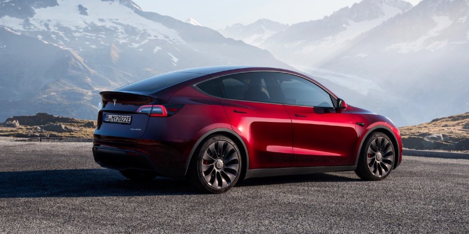 A red 2023 Tesla Model Y small electric SUV is parked.