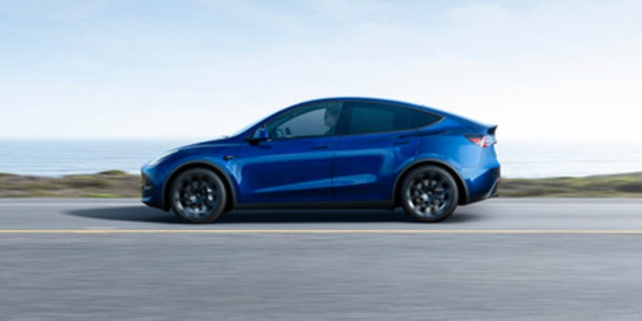 A blue 2023 Tesla Model Y small electric SUV is driving on the road. The only Tesla Top Safety Pick this year is the Model Y.