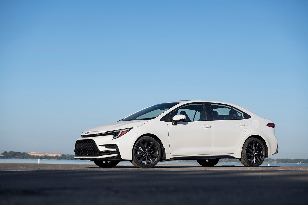 A white 2023 Toyota Corolla Hybrid car shows off its side profile.