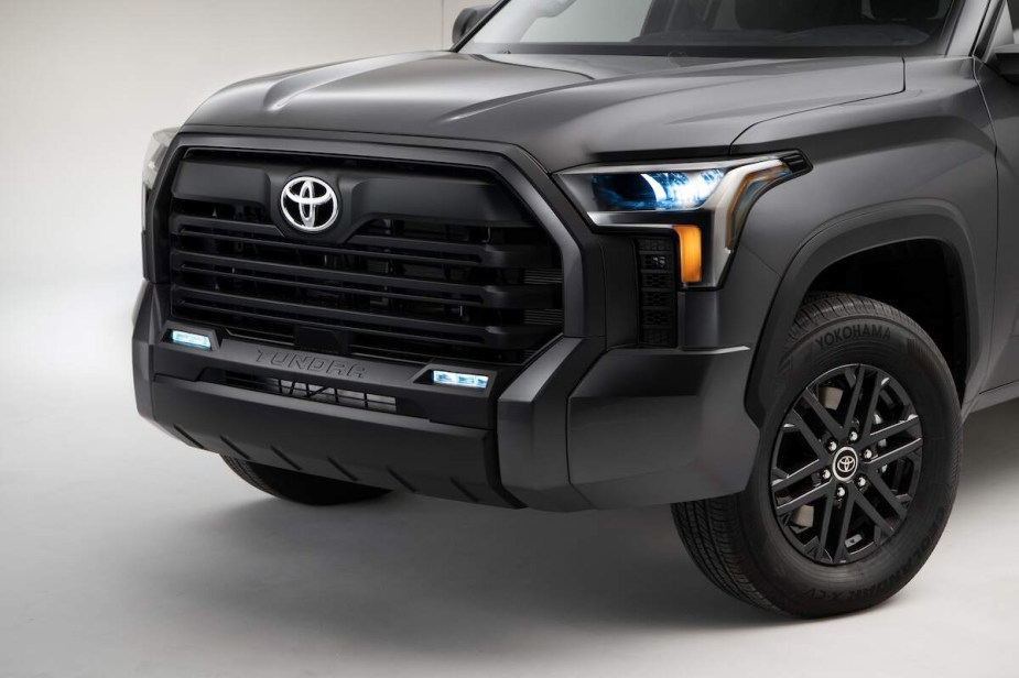 A silver 2023 Toyota Tundra, which is the Toyota that is the best, grille and headlights against a white background. 