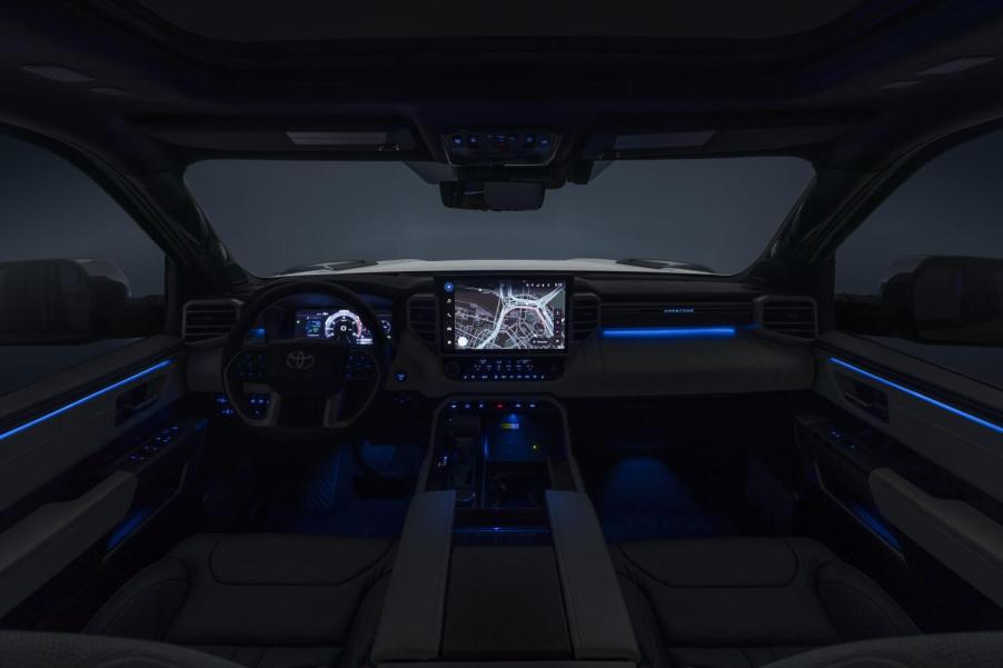 The interior of a 2023 Toyota Tundra at night with its infotainment touch screen and digital gauge cluster illuminated.