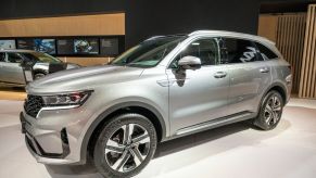 Silver 2023 Kia Sorento SUV on display at a motor show.