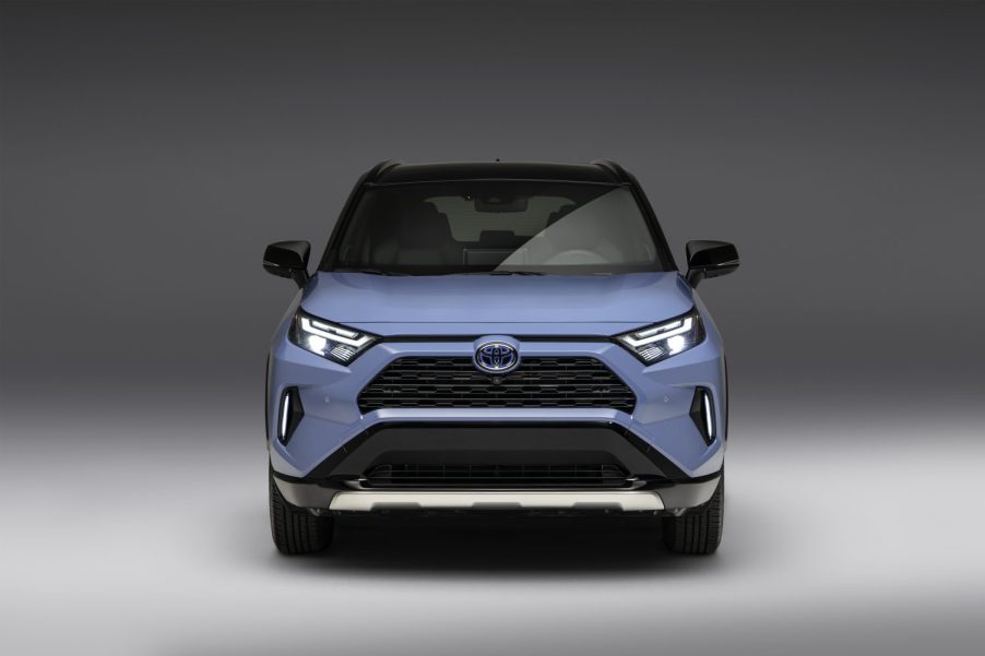 Press photo of a blue 2023 Toyota RAV4 front end in a white space.