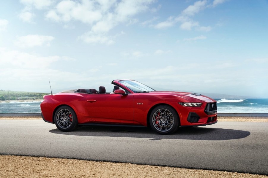 A bright red Ford Mustang GT Convertible shows off its drop top by the coast.