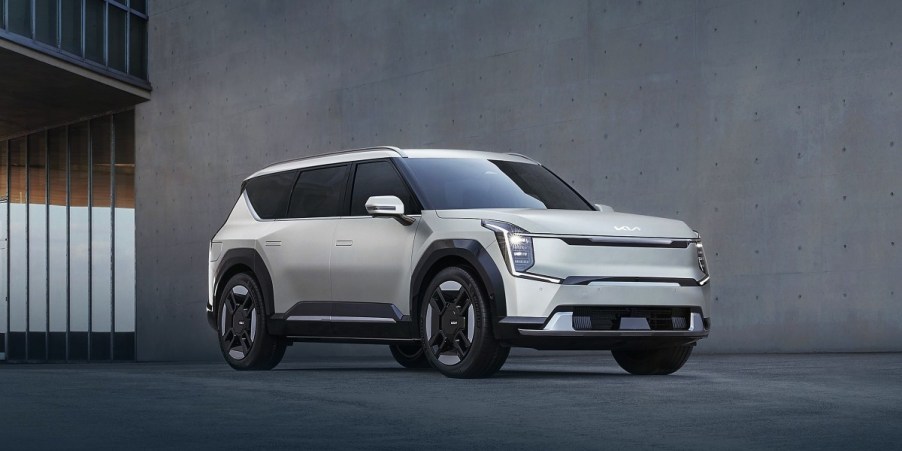 A gray 2024 Kia EV9 midsize electric SUV is parked in front of a gray wall.