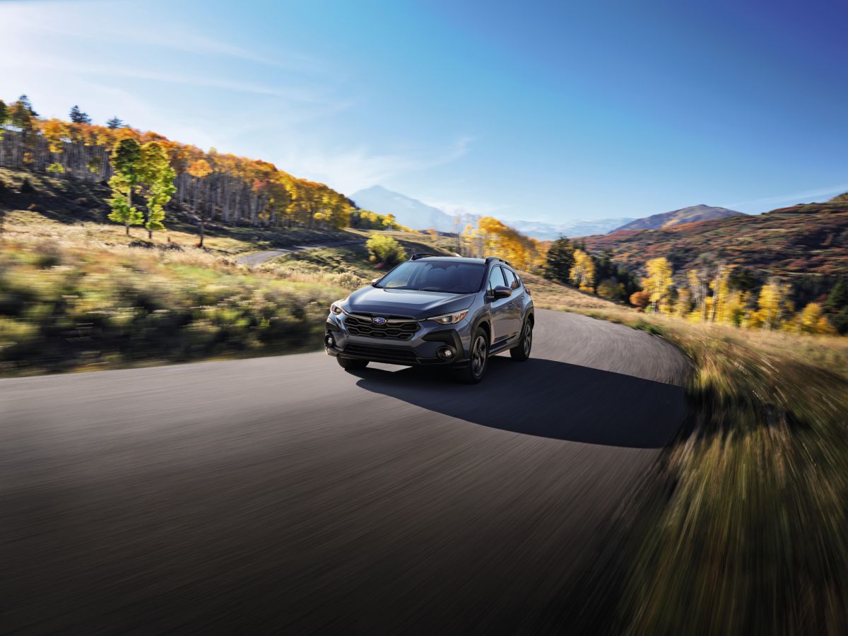 A 2024 Subaru Crosstrek driving down an open road.