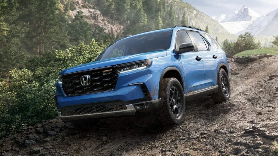 Blue 2023 Honda Pilot midsize SUV driving off-road