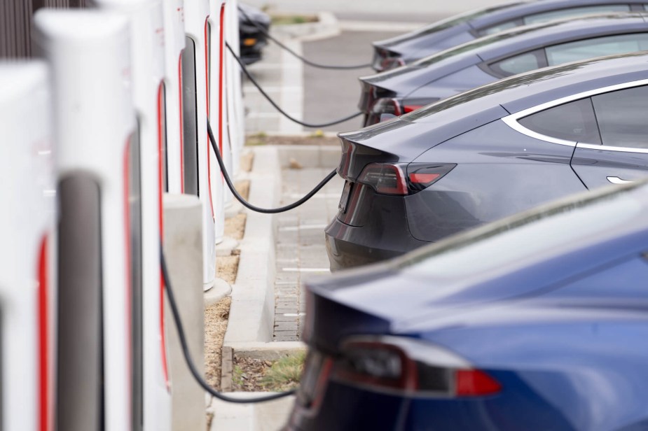 A line of EVs hooked up to public DC fast chargers. 