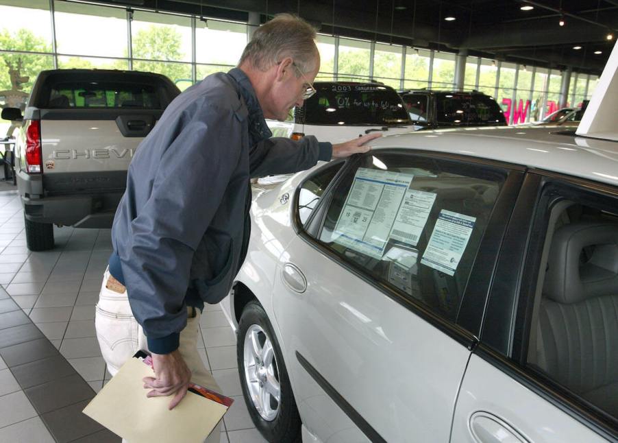 Customer looks at window sticker to see the new car price