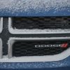 The Dodge emblem on the front of a snowy car grille