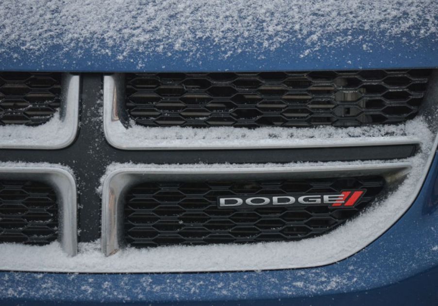 The Dodge emblem on the front of a snowy car grille