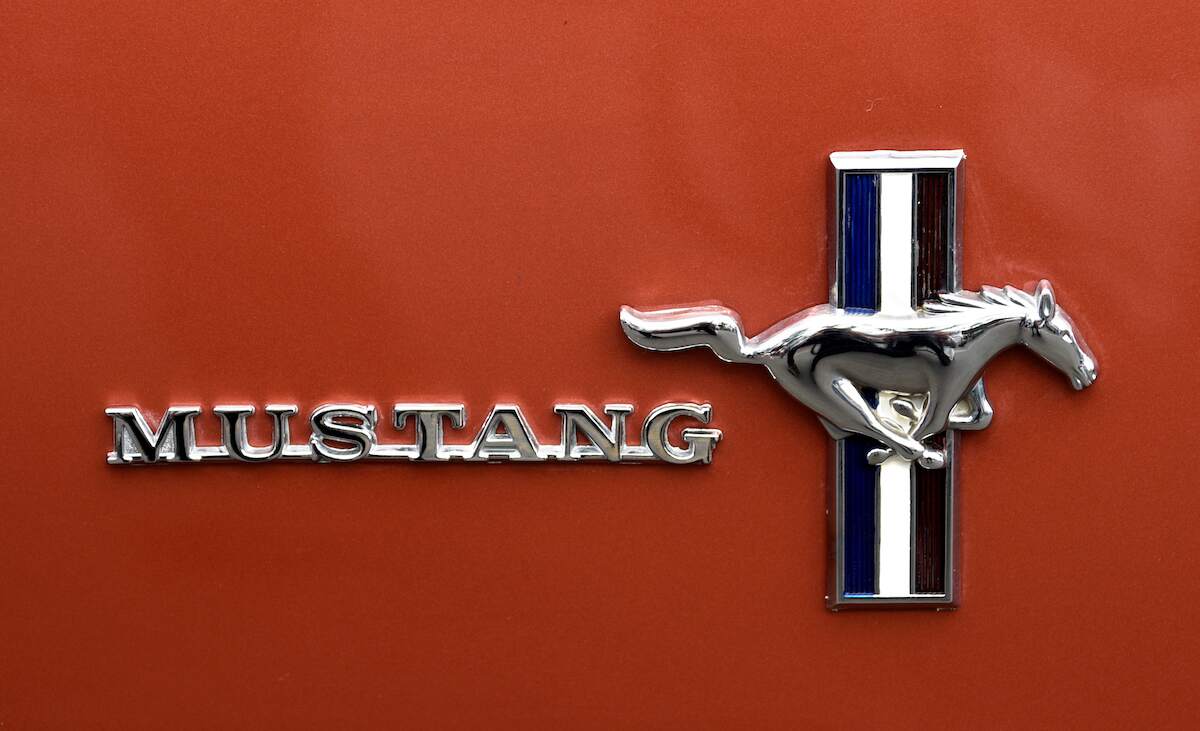 Ford Mustang logo on an orange car.