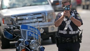 A police officer using a radar gun.