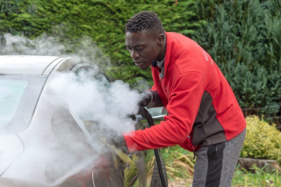 A professional detailer working on car windows