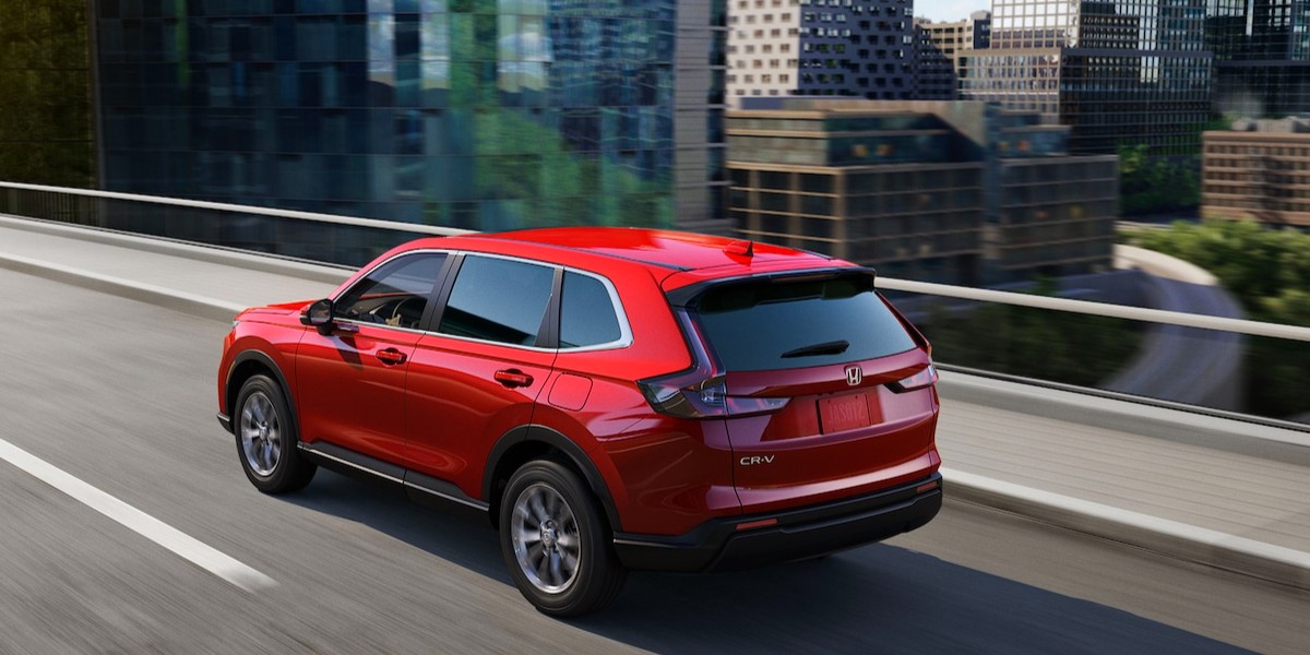 A red Honda CR-V driving down the highway.