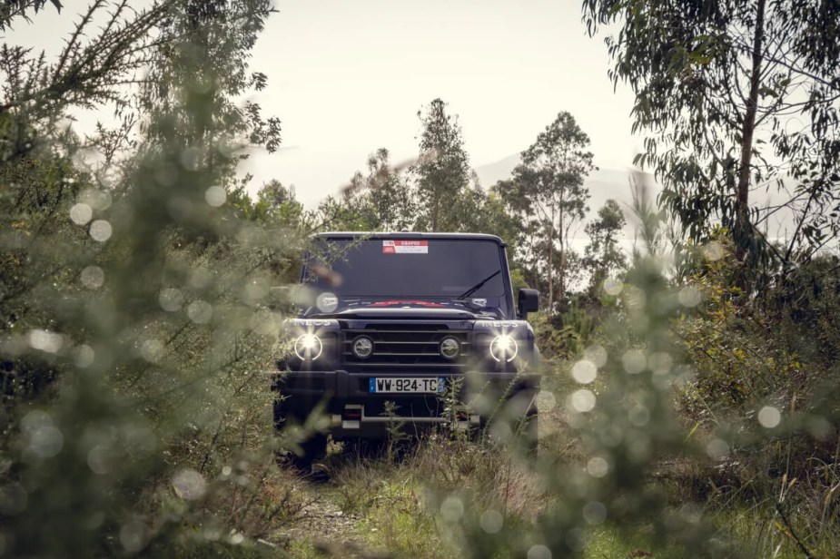 An Ineos Grenadier truck is parked in the woods.